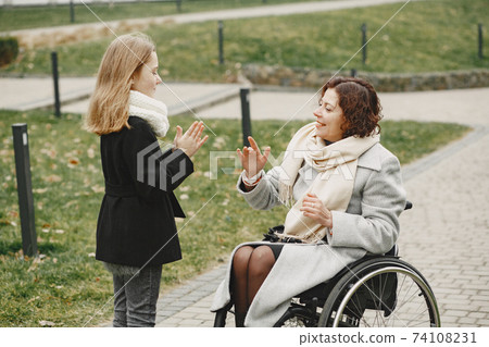 Mother in a wheelchair with hre daughter 74108231