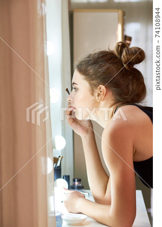 Woman applying brow tint 74108944