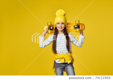 child girl in hat and sunglasses with yellow skateboard child girl in hat and sunglasses with yellow skateboard 74111950