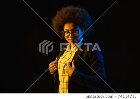 Half-length portrait of African-American girl isolated on black background. 74114715