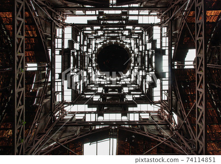 Looking up into dome ceilings there are vents and receiving light inside the architecture of an abandond ancient building. 74114851