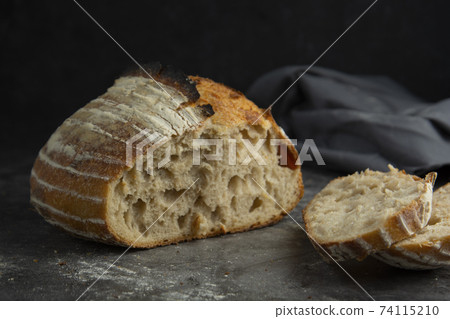 Sourdough rustic homemade healthy bread. Traditional bread, home baking concept. Sourdough rustic homemade healthy bread. Traditional bread, home baking concept. 74115210