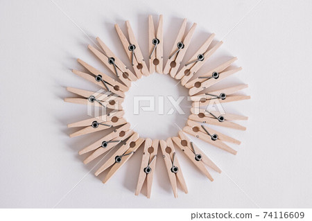 Group of wooden clothespins arranged in a circle isolated on white background. Copy space 74116609