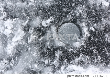 Ice fishing hole on the river in winter Ice fishing hole on the river in winter 74116792