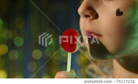 Close-up shot of stylish teenager caucasian kid girl lips licking lollipop with tongue 74117238
