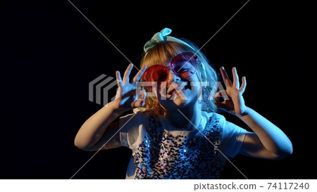 Fashion, gorgeous girl dancing alone, showing ok sign in futuristic night club with neon lights 74117240