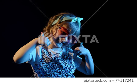 Fashion, gorgeous girl dancing alone, showing thumbs up in futuristic night club with neon lights Fashion, gorgeous girl dancing alone, showing thumbs up in futuristic night club with neon lights 74117241