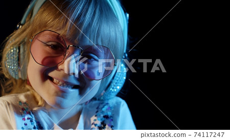Stylish trendy child kid in sunglasses at disco party cyberpunk club looking at camera and smiling 74117247