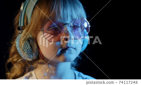 Stylish trendy child kid in sunglasses at disco party cyberpunk club looking at camera and smiling 74117248