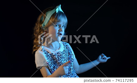 Futuristic hipster teen girl listening to musics, celebrating, dancing in neon lights at disco club Futuristic hipster teen girl listening to musics, celebrating, dancing in neon lights at disco club 74117295