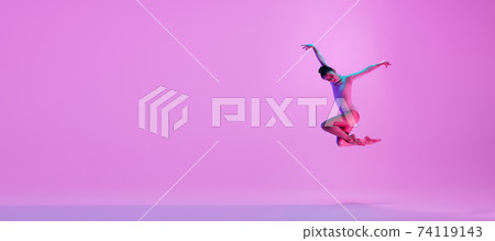 Young and graceful ballet dancer isolated on pink studio background in neon light. Art, motion, action, flexibility, inspiration concept. 74119143