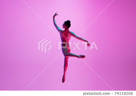 Young and graceful ballet dancer isolated on pink studio background in neon light. Art, motion, action, flexibility, inspiration concept. 74119208