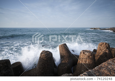 Concrete breakwater and splashing waves 74120248