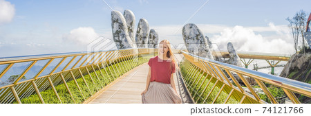 Young woman tourist at Famous tourist attraction - Golden bridge at the top of the Ba Na Hills, Vietnam BANNER, LONG FORMAT Young woman tourist at Famous tourist attraction - Golden bridge at the top of the Ba Na Hills, Vietnam BANNER, LONG FORMAT 74121766
