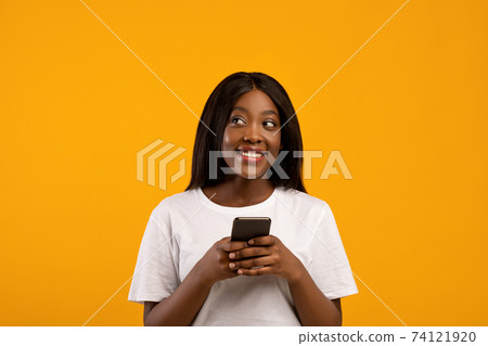 Smiling african american woman using mobile phone Smiling african american woman using mobile phone 74121920