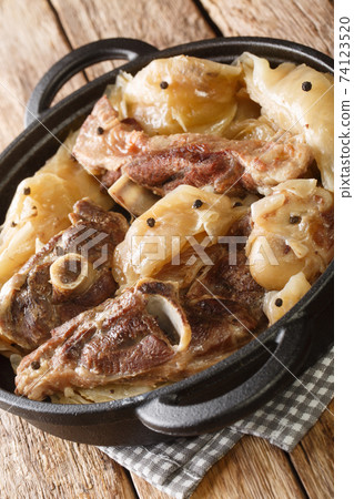 Tasty cooked Farikal Lamb and cabbage are layered and stewed with peppercorns close-up in a pan. Vertical 74123520