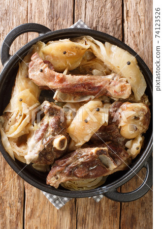 Farikal Lamb and cabbage are layered and stewed with peppercorns close-up in a pan. Vertical top view Farikal Lamb and cabbage are layered and stewed with peppercorns close-up in a pan. Vertical top view 74123526