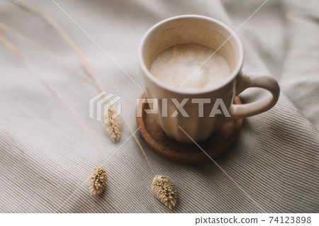 Cup of coffee with milk on beige textile. Still life morning breakfast concept. Cup of coffee with milk on beige textile. Still life morning breakfast concept. 74123898