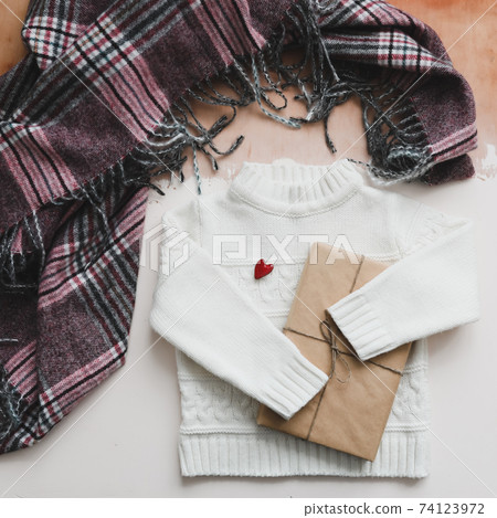 Red heart, a gift and a white knitted sweater. Concept of preparing heart gifts. Love, romance, Valentines Day. Flat lay, top view, copy space  74123972