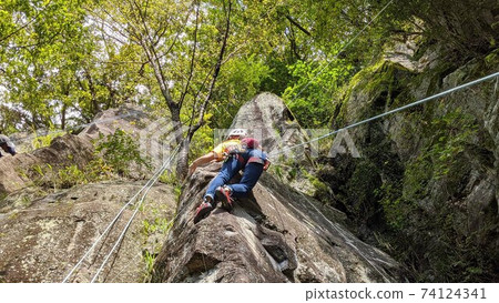 A woman rock climbing with a top rope A woman rock climbing with a top rope 74124341