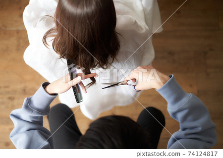 From above the hairdresser who cuts women's hair 74124817