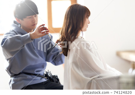 Hairdresser and female customer doing haircut Hairdresser and female customer doing haircut 74124820