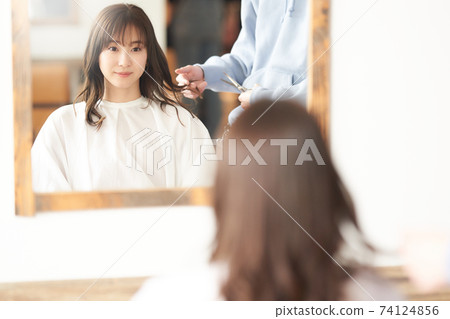 Young woman getting a cut at a beauty salon 74124856