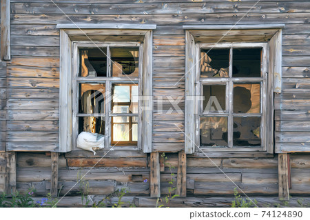 Old destroyed abandoned raw wooden house with the broken out windows Old destroyed abandoned raw wooden house with the broken out windows 74124890