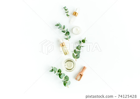 Eucalyptus essential oil, eucalyptus leaves on white background. Natural, Organic cosmetics products. Medicinal, Natural Serums. Flat lay, top view. Eucalyptus essential oil, eucalyptus leaves on white background. Natural, Organic cosmetics products. Medicinal, Natural Serums. Flat lay, top view. 74125428