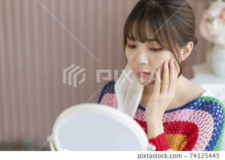 Young woman worrying about rough skin due to mask toothache Young woman worrying about rough skin due to mask toothache 74125445