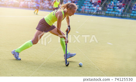 Young field hockey female player in attack Young field hockey female player in attack 74125530
