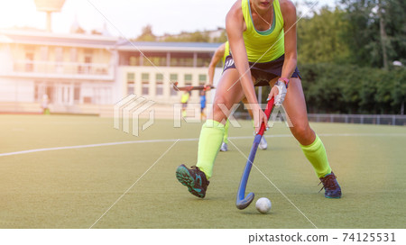 Young field hockey female player in attack Young field hockey female player in attack 74125531