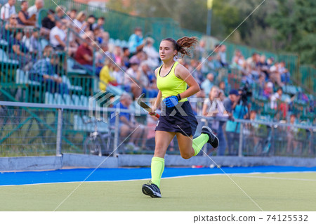 Young field hockey player runs in attack Young field hockey player runs in attack 74125532