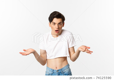 Lgbtq community. Confused gay man in crop top shrugging and staring at camera, cant understand, standing over white background 74125590