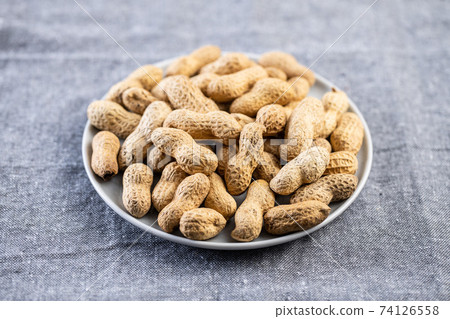Roasted peanuts. Tasty groundnuts on plate. Roasted peanuts. Tasty groundnuts on plate. 74126558