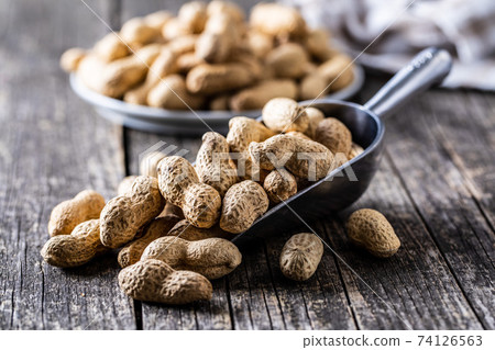 Roasted peanuts. Tasty groundnuts in metal scoop. Roasted peanuts. Tasty groundnuts in metal scoop. 74126563