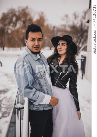 Hispanic man in oversized denim jacket and woman in hat leather biker jacket Hispanic man in oversized denim jacket and woman in hat leather biker jacket 74126735