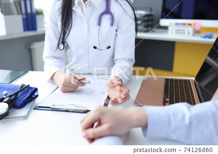 Doctor listening to patients complaints in office closeup Doctor listening to patients complaints in office closeup 74126860