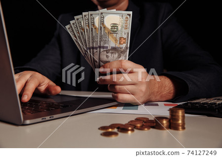 Businessman earn a lot of money from internet online by only using laptop. Investment concept 74127249