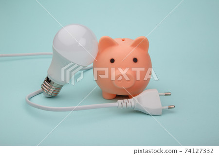 Pink piggy bank, lamp and white cord, power savings concept 74127332