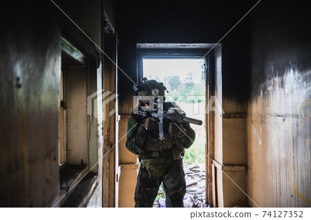 Soldier in full US MARSOC equipment entering abandoned building, aiming different angles with MK18 assault rifle Soldier in full US MARSOC equipment entering abandoned building, aiming different angles with MK18 assault rifle 74127352