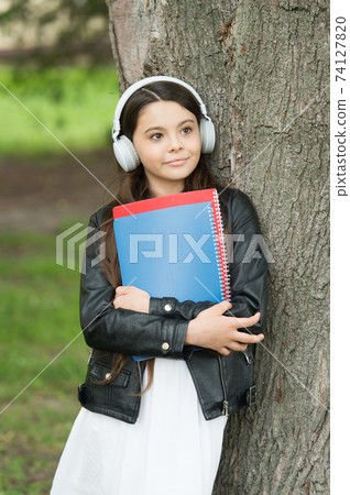 Girl listening audio carry textbooks relaxing park background 74127820