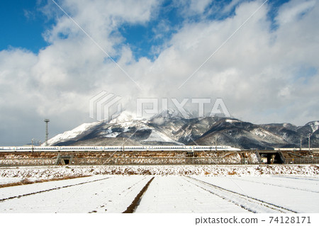 Tokaido Shinkansen running at the foot of Mt. Ibuki with snow 74128171