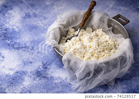 Homemade cottage cheese on blue background Homemade cottage cheese on blue background 74128517