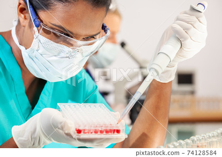 Asian Female Scientist Wearing Face Mask With Blood Sample In Laboratory 74128584