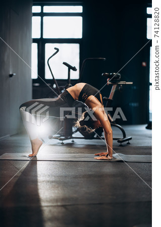 Slim athletic woman doing exercise bridge at gym 74128820