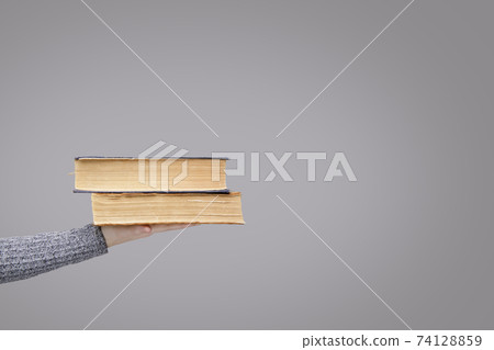 stack of old books in the palm of an invisible person stack of old books in the palm of an invisible person 74128859