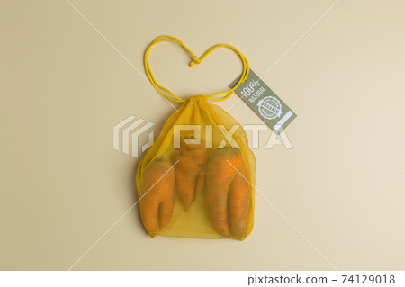 trendy ugly carrots in yellow eco reusable mesh bag creative concept zero waste shopping trendy ugly carrots in yellow eco reusable mesh bag creative concept zero waste shopping 74129018