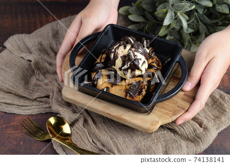 Hand Serve of Fresh Baked Soft Chocolate Chocolate Chip with Ice-Cream Hand Serve of Fresh Baked Soft Chocolate Chocolate Chip with Ice-Cream 74138141