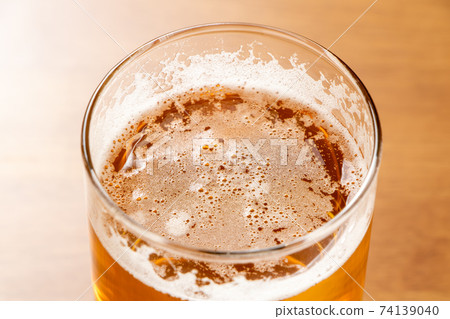 傾倒後隨著時間流逝泡沫消失的啤酒。 傾倒後隨著時間流逝泡沫消失的啤酒。 74139040